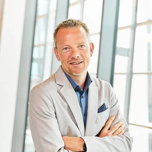 Portrait von Christian Schulz, der freundlich in die Kamera lächelt.