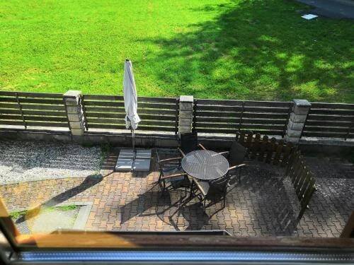 an umbrella sitting next to a bench with a table at Penzion u lázní in Velké Losiny