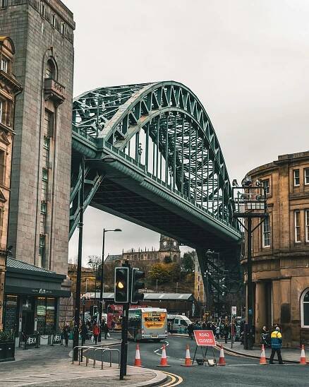 Free Dynamic urban scene featuring the Tyne Bridge, Newcastle upon Tyne, showcasing local architecture and bustling street life. Stock Photo