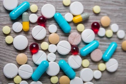 Lot of colorful medication and pills from above on grey wooden background. Copy space. Top view, frame. Painkillers, tablets, generic , drugs. — Stock fotografie