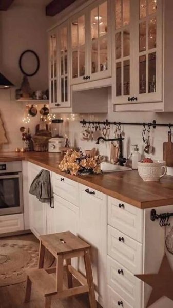 a kitchen filled with lots of white cabinets and wooden counter top space next to an oven