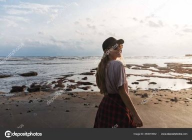 Romantický záběr krásné bezstarostné ženy batohem, cestování po celém světě, výlet na Indonésii Bali, podívejte se zpět na úsměv fotoaparát, jak se těší relaxační pohled na černé písečné sopečné pláže a pobřeží oceánu