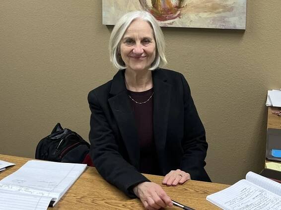 Susan Shore smiling for a picture at her office desk.