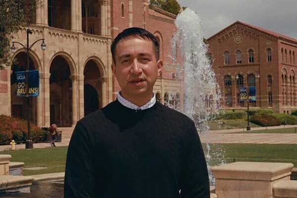 Francisco Reyes, in dark sweater, with Royce Hall in background