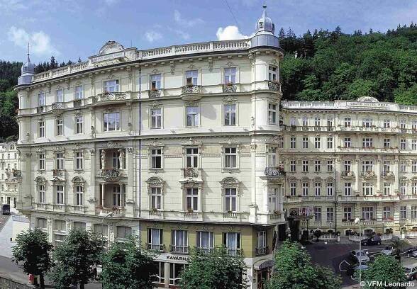 Grandhotel Pupp Карловы Вары Экстерьер фото The photo shows a beautiful architectural scene featuring two elegant buildings. The structures exhibit a classic design with intricate details, large windows, and ornate balconies. They are painted in a light color, possibly cream or pale yellow, wh