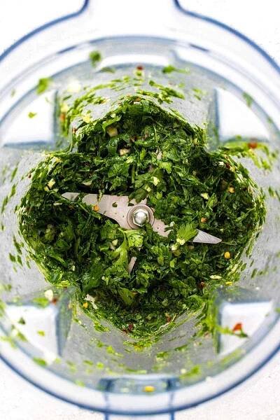 Green leaves chopped into smaller pieces using a blender.