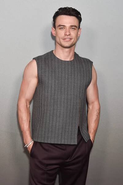 Thomas Doherty in a gray top and maroon jeans on the red carpet for "Tell Me Lies"