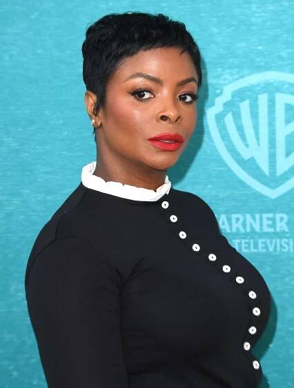 Janelle James wearing a black shirt with white buttons and her hair in a pixie cut