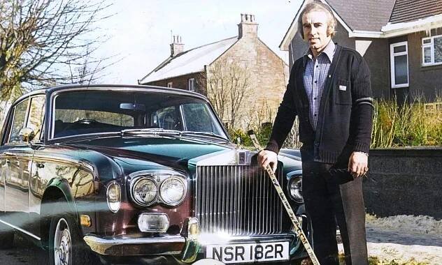Tom Stewart with an hockey stick as he satnds beside a Rolls-Royce car.