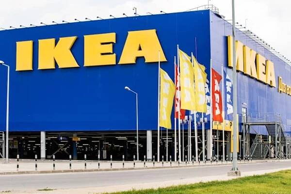 Large blue IKEA store exterior with yellow signage and multiple flags.