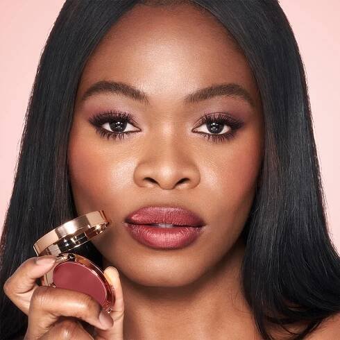 Pillow Talk Lip and Cheek Glow in Colour of Passion on deep tone model