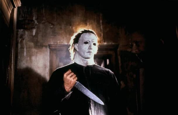 Michael Myers in "Halloween" wearing a creepy mask, holding a dagger. 