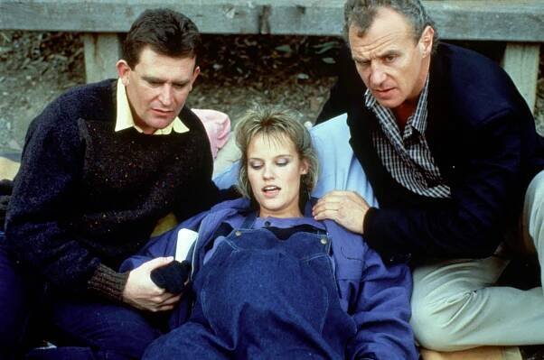 Jim and Des sit over Daphne, who is in labour, in Neighbours