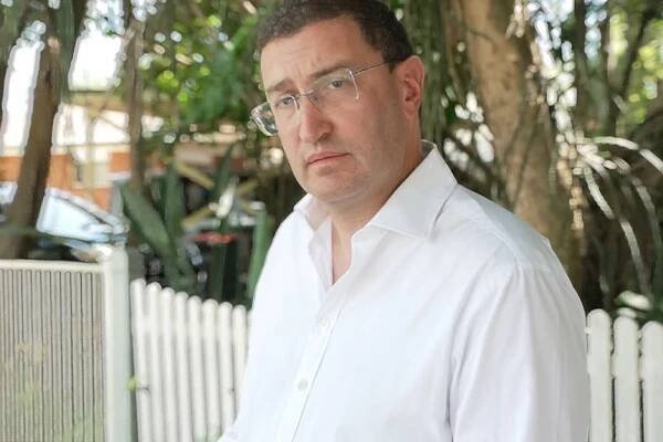 Julian Leeser Liberal MP for Berowra stands outdoors and looks at the camera