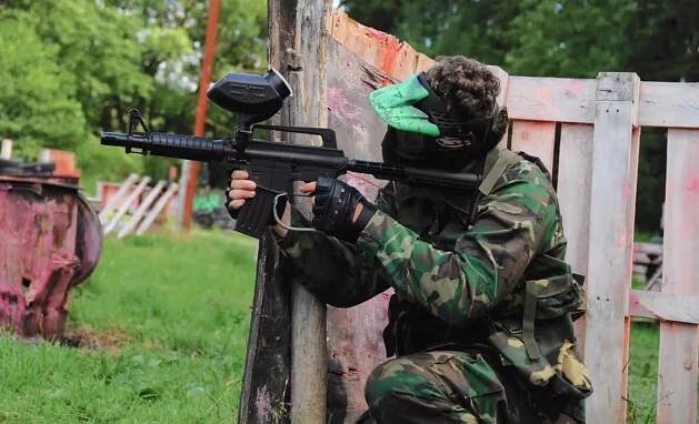 Dítě ve výbavě hrající paintball
