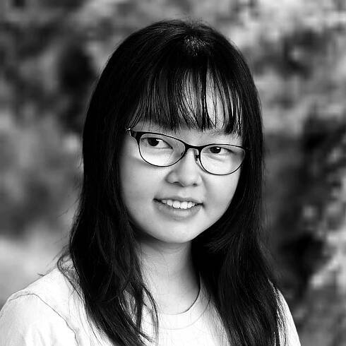Grayscale headshot photo of Michelle Chen wearing glasses and smiling at the viewer.
