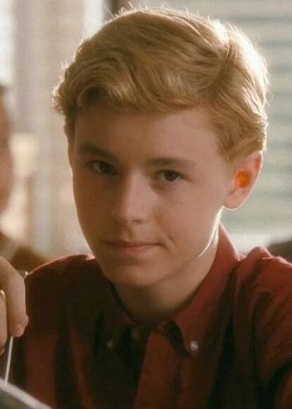 a young boy holding a knife and fork in his hand