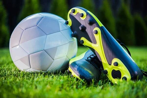 Fotbalový turnaj koncept moderní fotbalový míč a hráč kopačky boty. Tým sportovní téma. — Stock obrázek