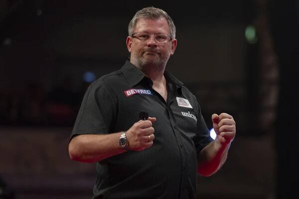 James Wade celebrates a darts match victory.