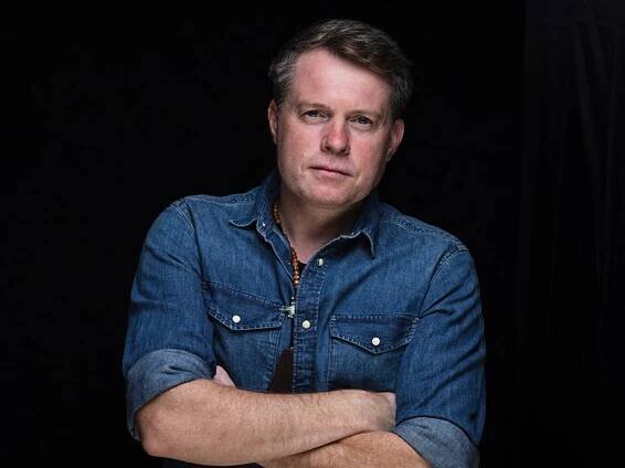 Promobild von Jimmy Kelly; er steht mit verschränkten Armen vor schwarzem Hintergrund