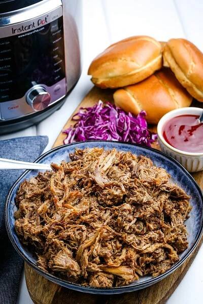 Instant pot pulled pork on a cutting board.