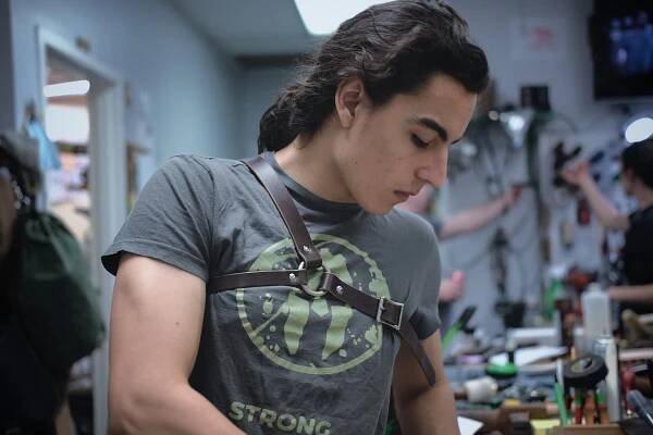 A man in a gray shirt is wearing a Monster Hunter Chest Harness.