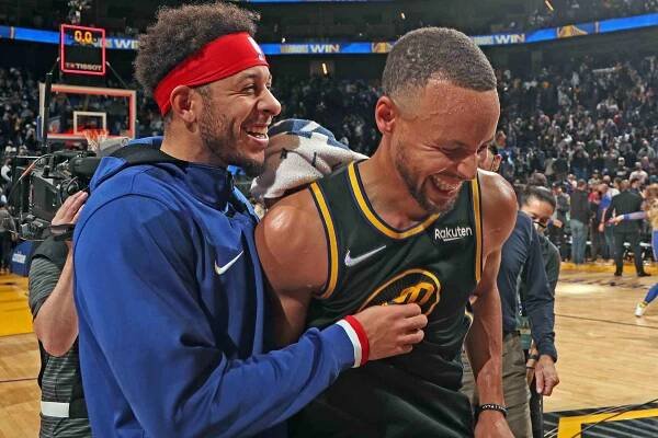Stephen Curry #30 of the Golden State Warriors and Seth Curry #31 of the Philadelphia 76ers hug on court after the game on November 24, 2021