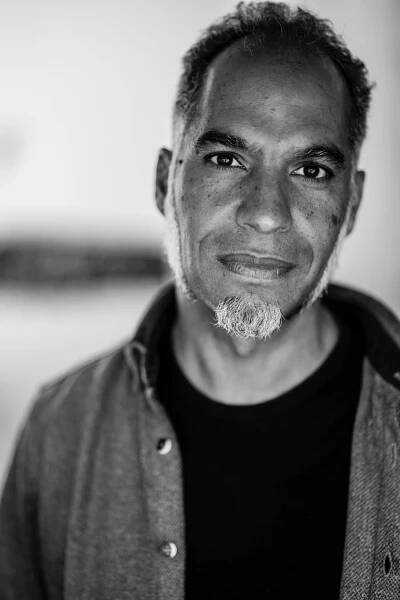 a black and white photo of artist, writer, and curator Charles Campbell a man with short hair, brown eyes, and a goatee