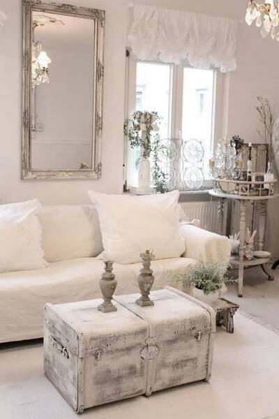 a living room filled with white furniture and lots of pillows on top of it's covers