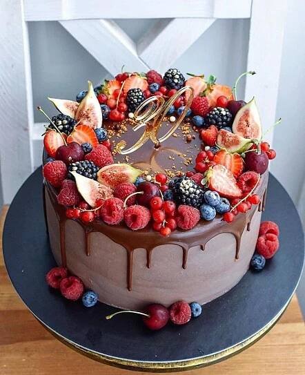 a chocolate cake topped with fresh berries, raspberries and other fruit toppings
