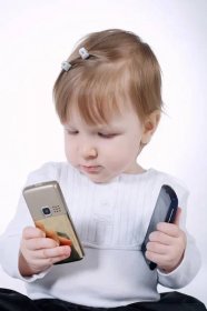 Legrační holčička s dvěma mobilními telefony na bílém — Stock obrázek