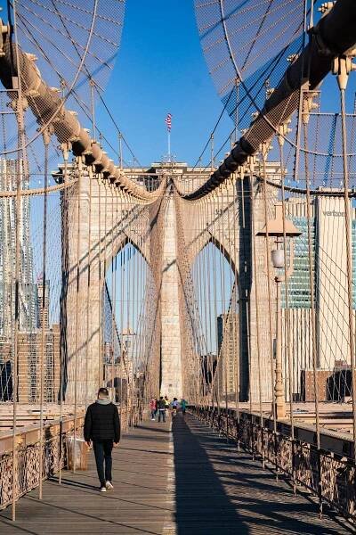 People crossing the center of the Brooklyn Bridge