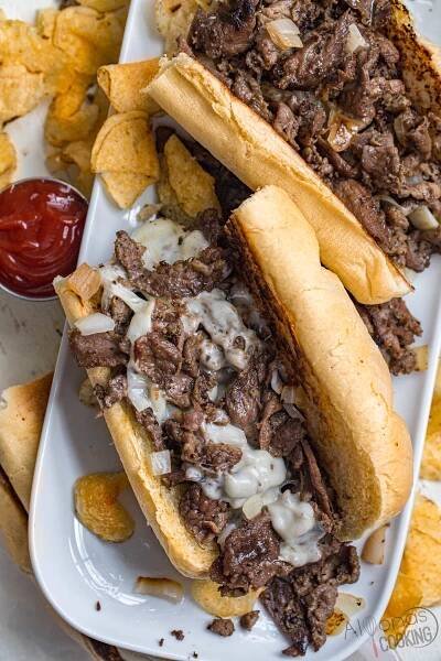 The only ingredients in an Authentic Philly cheesesteak are thinly sliced steak, fried onions, and cheese! This Philly cheesesteak recipe is true to the original Cheesesteak sandwich and is made with tender shavings of beef, sauteed onions, and cheese all tucked inside toasted long bread! 