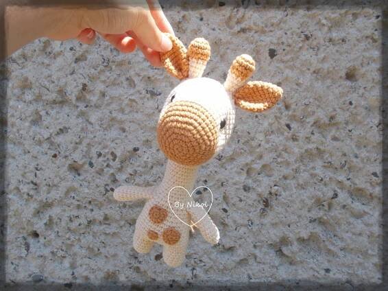 a stuffed giraffe being held by someone's hand
