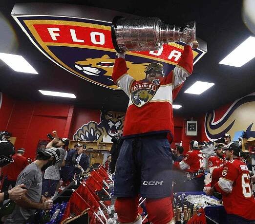 Sam Reinhart #13 of the Florida Panthers lifts the cup in the locker room during their team celebration after beating the Edmonton Oilers in Game Six of the 2025 Stanley Cup Final at the Amerant Bank Arena on June 17, 2025 in Sunrise, Florida