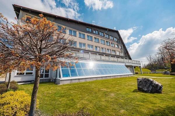 a building with a tree in front of it at HOTEL AGRI in Soběšice