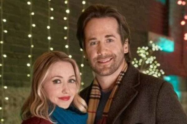 Emily Tennant and Niall Matter smile on set of "Holiday Hotline" movie on Hallmark Channel.