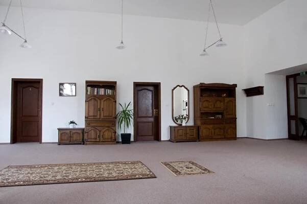 a large room with wooden doors and a rug at Penzion Zámek Rozsochatec in Rozsochatec