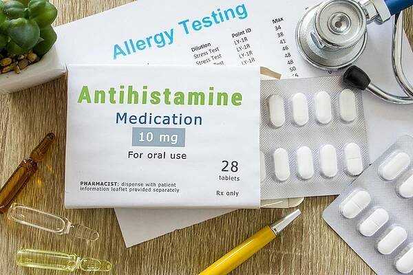 antihistaminika nebo koncepční fotografie léku na alergii. na stole lékaře je balení se slovem "antihistaminikum" a pilulkami pro léčbu alergie a přecitliv ělosti - puchýř trauma - stock snímky, obrázky a fotky