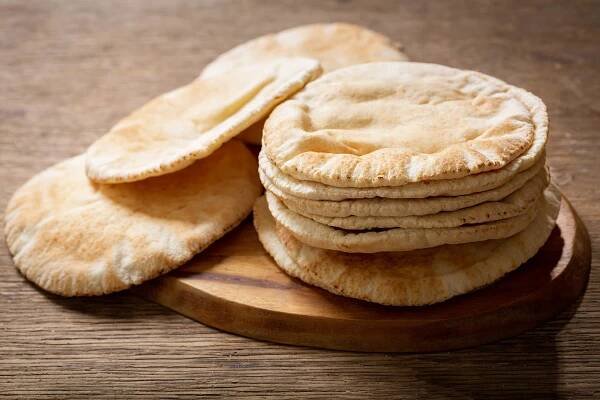fresh pita bread on a rustic wooden table