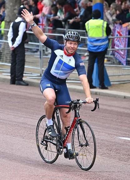 Sir Chris Hoy waves while cycling in the Platinum Jubilee Pageant.