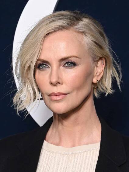 Charlize Theron with a deep side part tousled bob, an A-line bob hairstyle