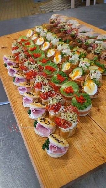 a wooden cutting board topped with lots of different types of food on top of it