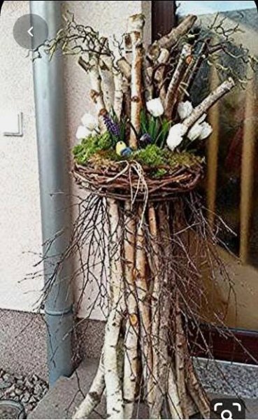 a bunch of branches that have been placed in front of a building with flowers on them