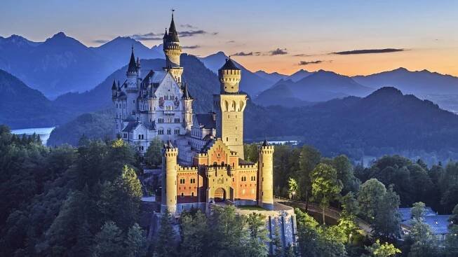 Schwangau: Schloss Neuschwanstein in der Abenddämmerung beleuchtet vor Tannheimer Bergen, Ammergauer Alpen ©lookphotos (Andreas Strauß)