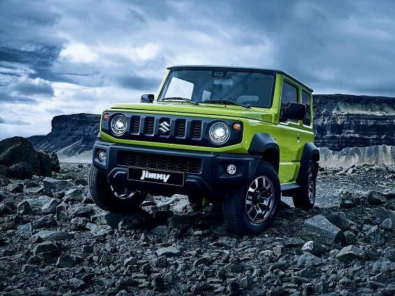 Lime green Suzuki Jimny driving on rocky terrain.