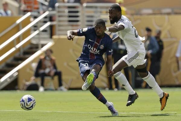 Paris Saint-Germain's Ousmane Dembele scores his side's second goal besides Real Madrid's Antonio Rudiger during the Club World Cup semifinal soccer match between PSG and Real Madrid in East Rutherford, N.J., Wednesday, July 9, 2025. (AP Photo/Adam Hunger)