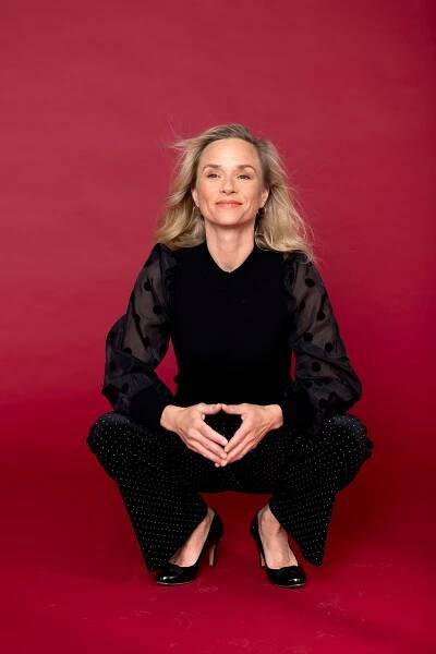 Annett Fleischer in einem eleganten schwarzen Outfit un offenen langen blonden Haaren