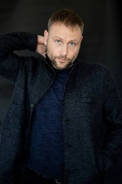 Max schwarz gekleidet mit Hand im Nacken