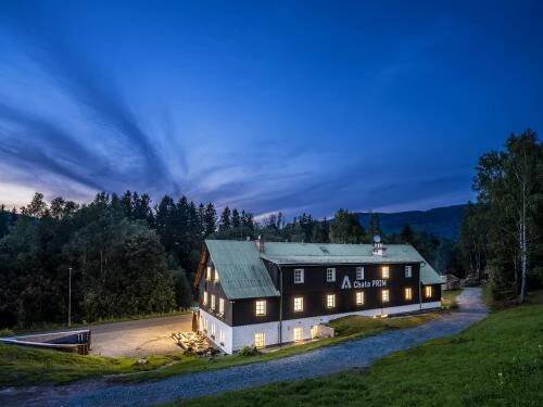 a large barn with a green roof at night at Chata Prim in Deštné v Orlických horách